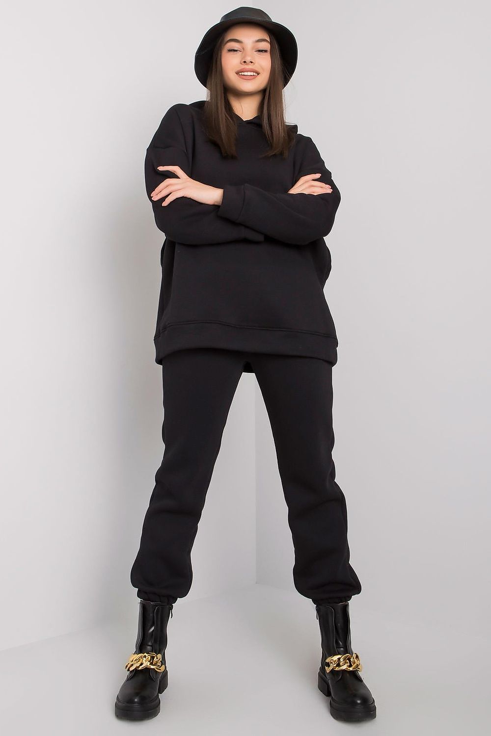 Stylish model dressed in an exquisite black BFG cotton-blend sweatshirt set, featuring a hood and elastic waistband, complemented by trendy boots.