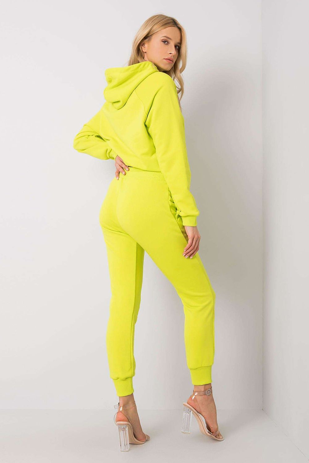 Back view of a model wearing luxury BFG cotton spandex hoodie and fitted pants set in neon yellow, highlighting the trendy features of the outfit.