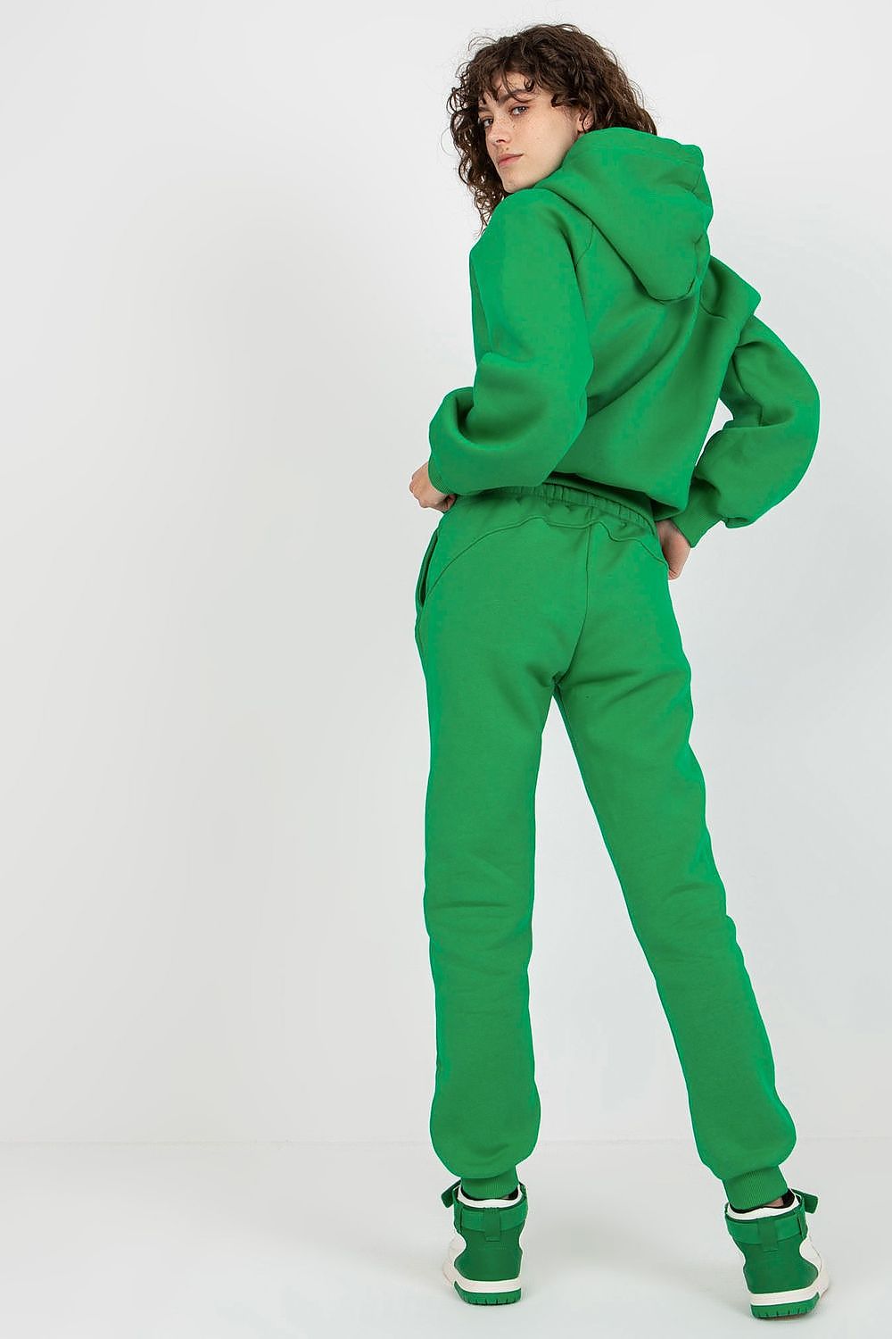 Back view of a model in Ex Moda's green cotton-blend sweatshirt set, highlighting the elegant hood and fitted long pants.