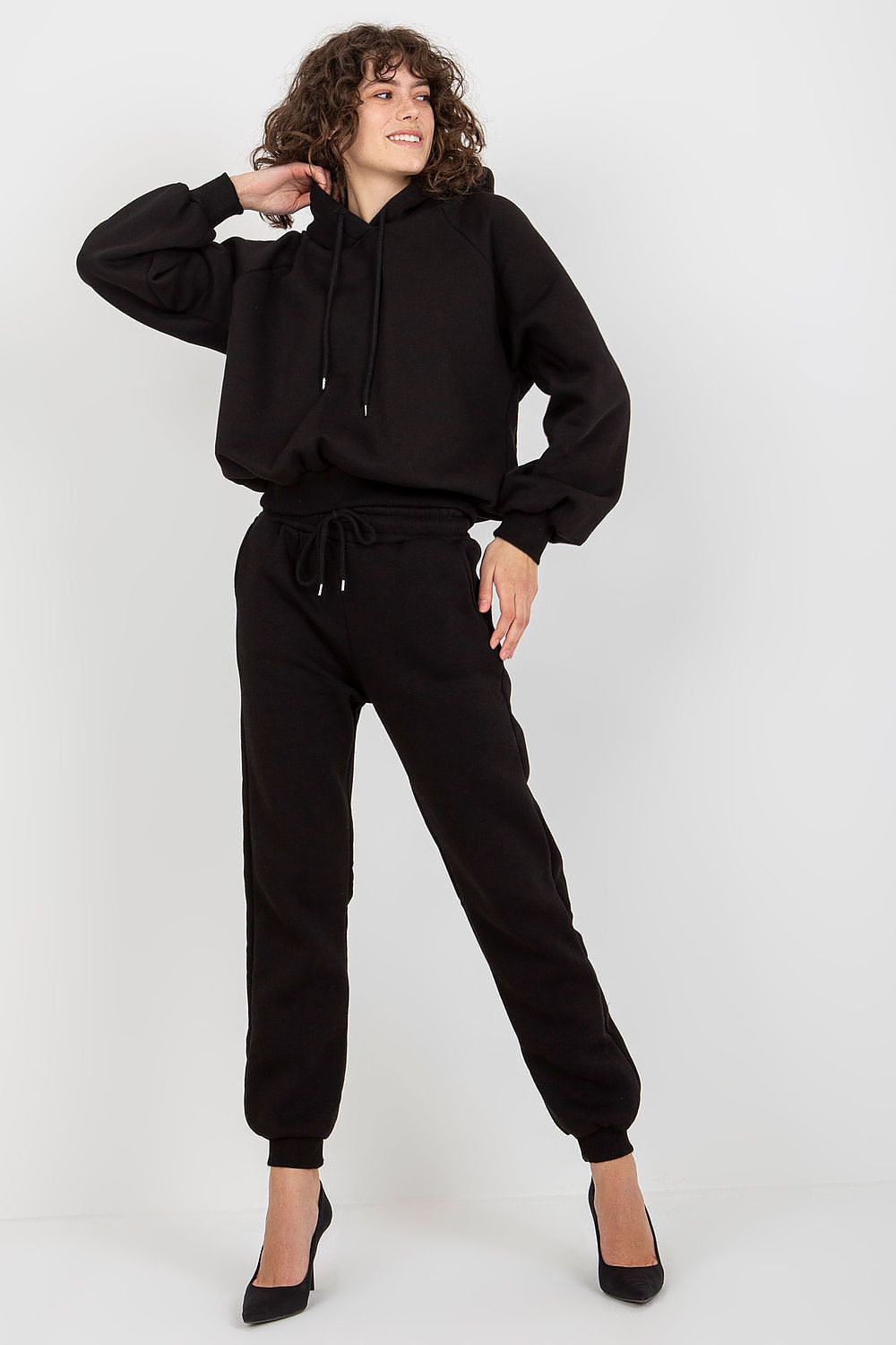 Model showcasing Ex Moda's black cotton-blend sweatshirt set, featuring a chic hoodie and tailored long pants, designed for versatile luxury.