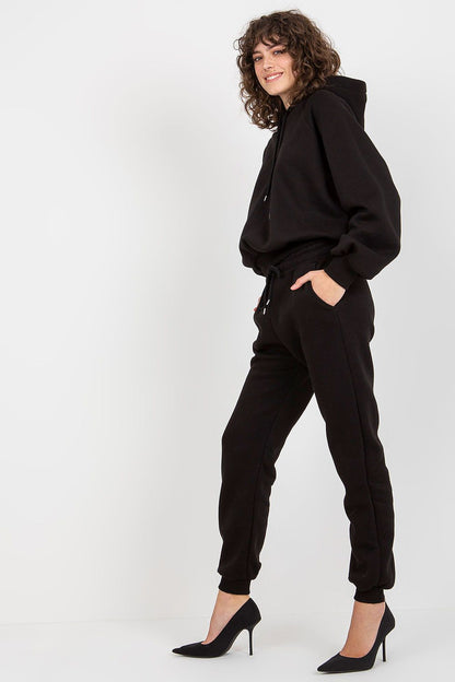 Ex Moda elegant black cotton-blend sweatshirt and pants set with hood, model showcasing stylish silhouette and high heels.