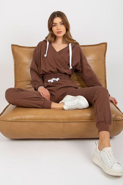 Ex Moda luxury brown sweatshirt set, portrayed with model seated on a stylish chair, emphasising the trendy cropped design and tie waist of the pants.