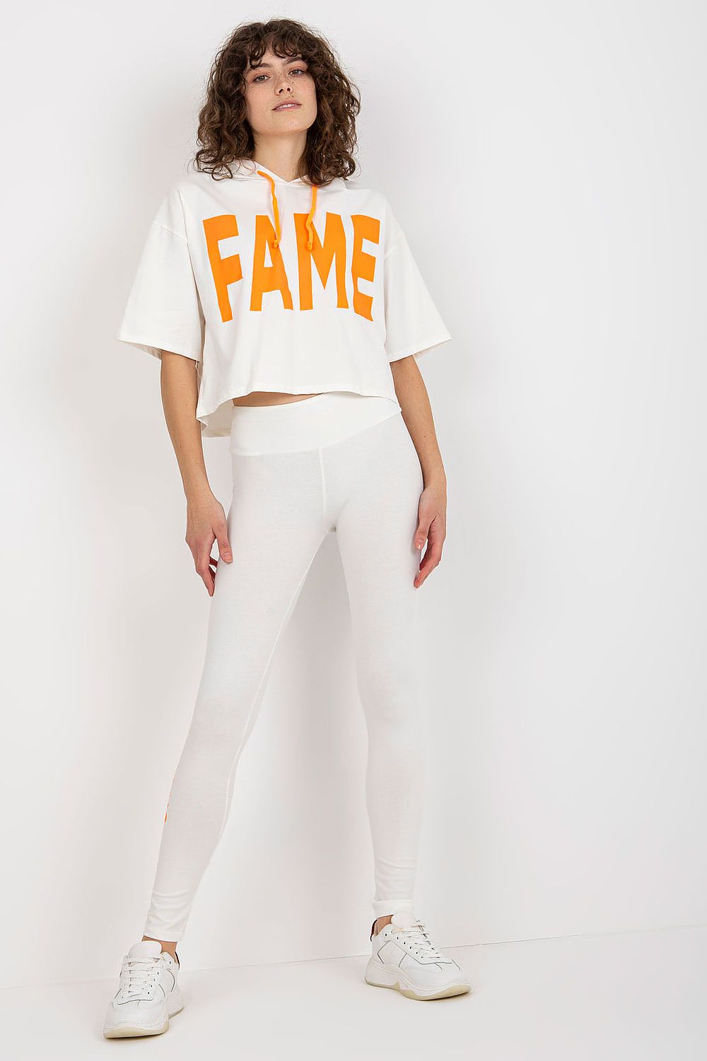 Ex Moda luxury women's cotton sweatshirt and leggings set in white featuring bold orange lettering. The sweatshirt showcases a loose fit with a hood, paired with form-fitting leggings crafted for comfort.