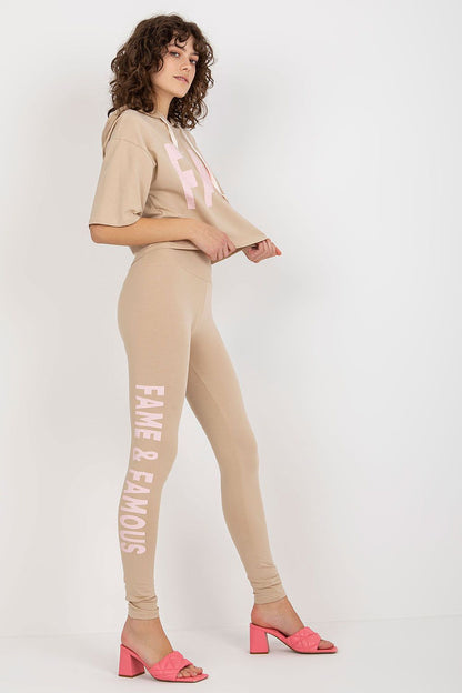 Sophisticated side profile of a woman modelling Ex Moda's cotton sweatshirt and leggings set, showcasing the loose fit crop top and stylish pink block heels.