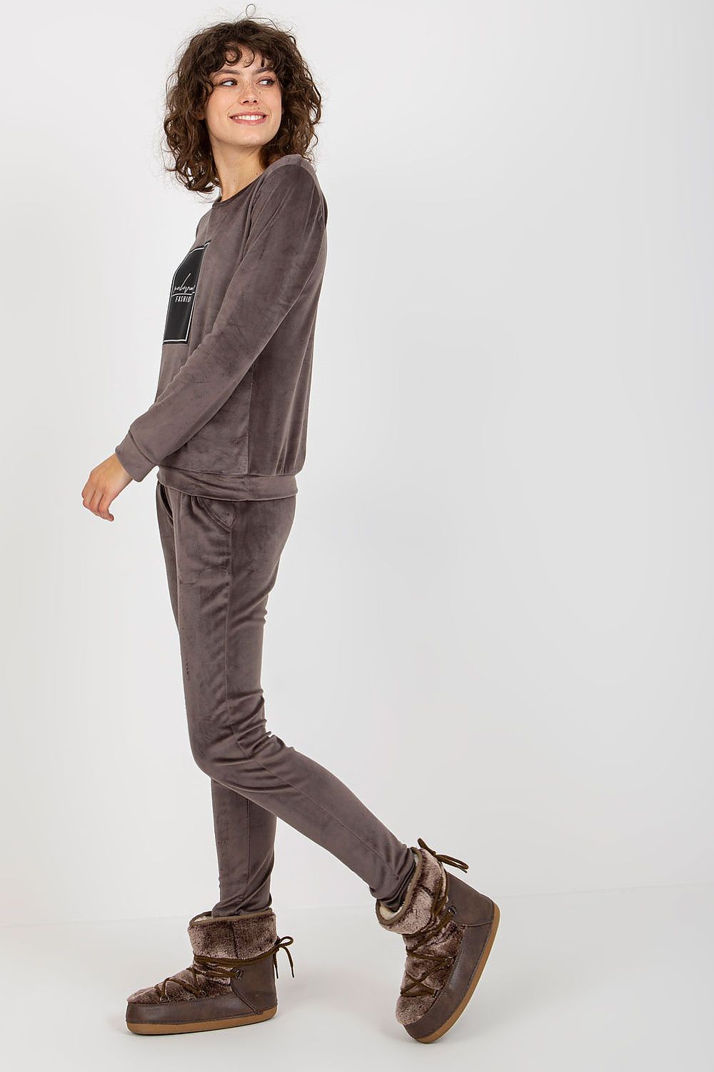 Luxurious velour tracksuit set featuring a stylish sweatshirt and long pants, model showcasing the outfit with a confident smile, perfect for casual elegance by Relevance.