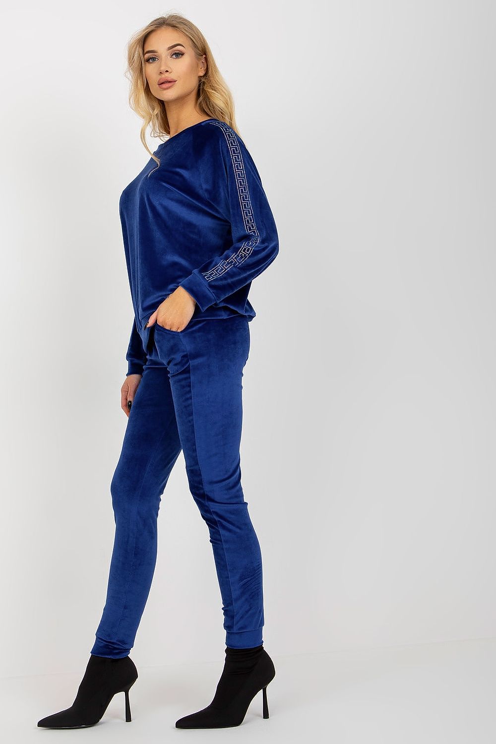 Elegant blue velour set with rhinestone-embellished long sleeves, paired with sleek trousers, ideal for a sophisticated appearance by Relevance.