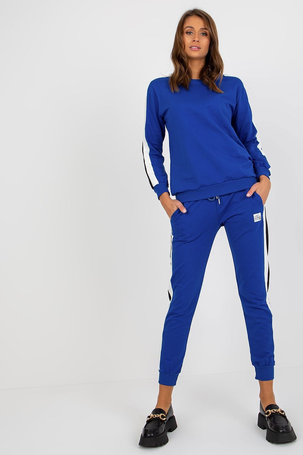 Luxurious blue cotton-spandex sweatshirt set by Relevance featuring two-tone stripes, paired with elegantly tailored tie-waist pants. Model showcasing a stylish look with long sleeves and comfortable slip pockets.