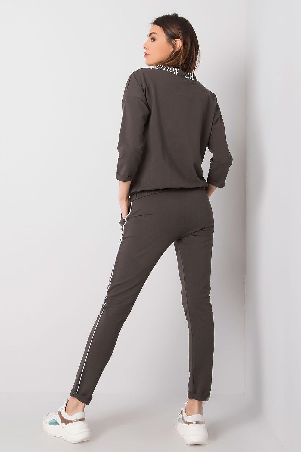 Back view of a woman adorned in the Elegant Women's 2-Piece Tracksuit Set by Relevance, highlighting the elegant sporty style with a stylish collar and comfortable fit.