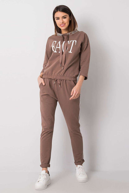 A chic woman posing in the Elegant Women's 2-Piece Tracksuit Set by Relevance, featuring a luxurious design with a 3/4 sleeve sweatshirt in a beautiful brown shade paired with matching pants, epitomizing modern style.