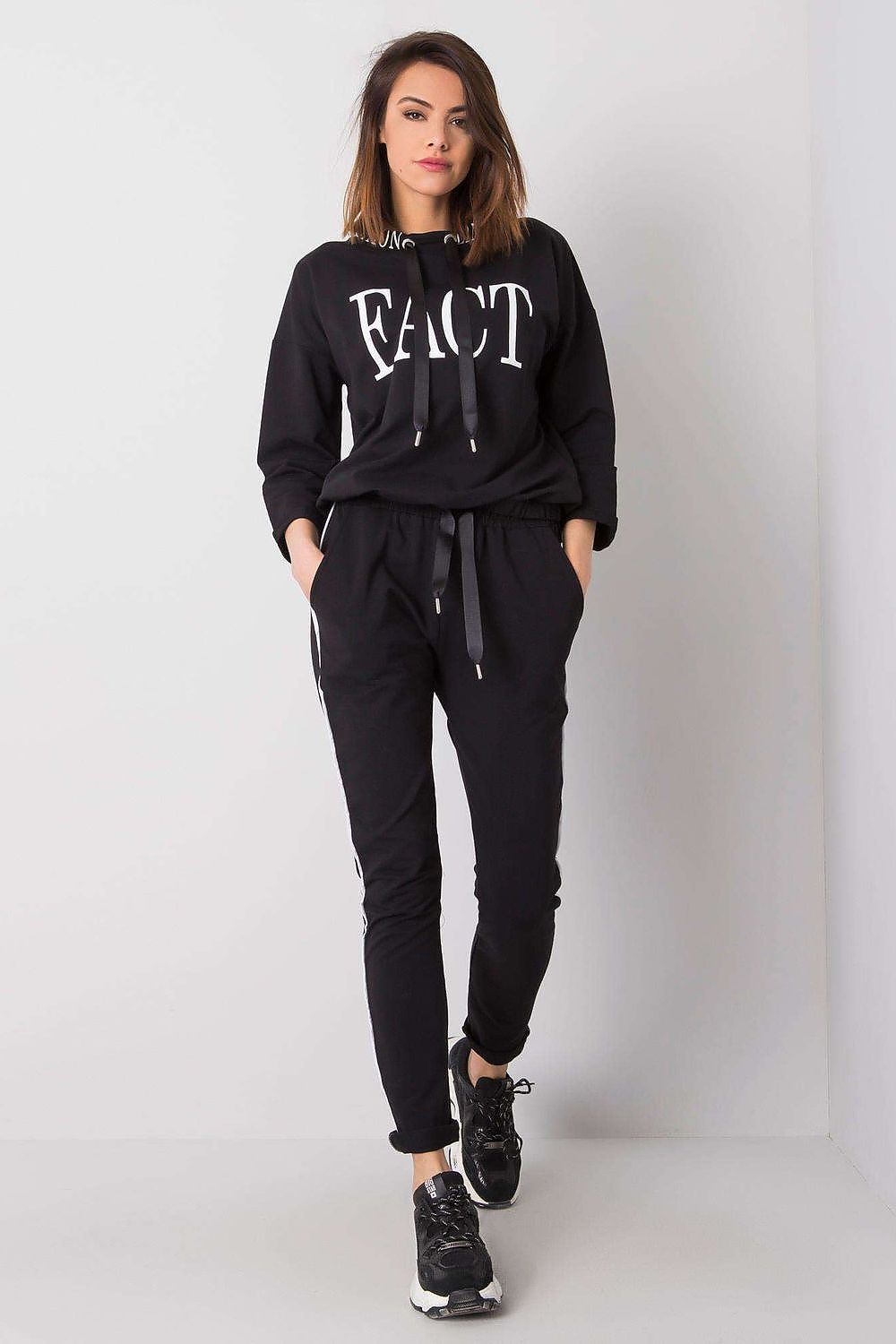 Fashion-forward women's tracksuit in classic black with a bold front design, featuring a 3/4 sleeve sweatshirt and stylish long pants by Relevance.