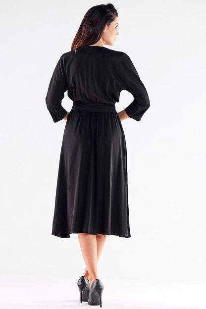 Elegant black midi dress by Awama featuring a trapezoidal bottom and a belted waist, showcasing a sophisticated back view ideal for various occasions.