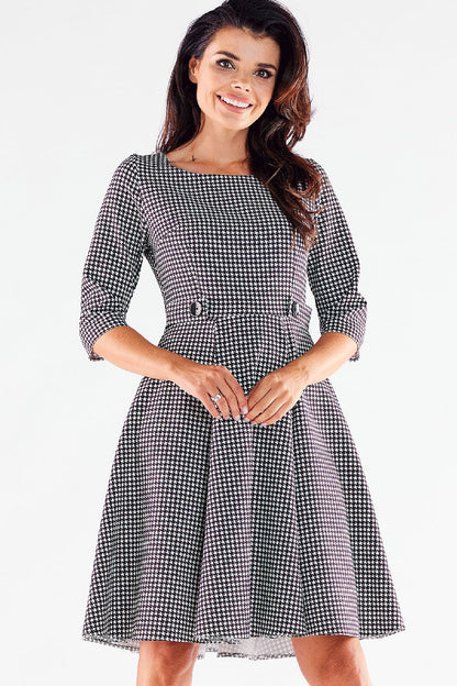 Chic black and white houndstooth Awama daydress displaying a refined style with decorative buttons for an elegant touch.