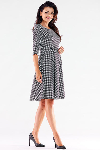 Stylish Awama daydress in houndstooth, boasting a sophisticated fit and decorative buttons for added charm.