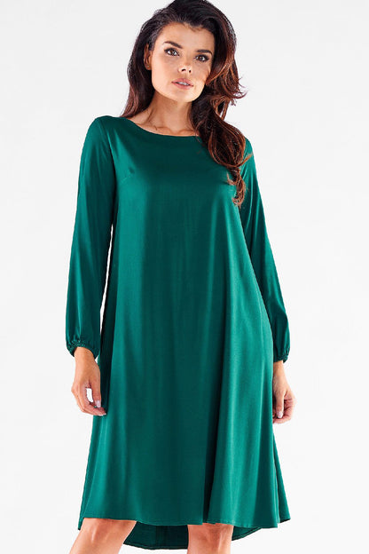 Chic woman's trapezoidal daydress in rich green, with long sleeves and a flattering silhouette, perfect for casual to evening wear, displayed from the front.