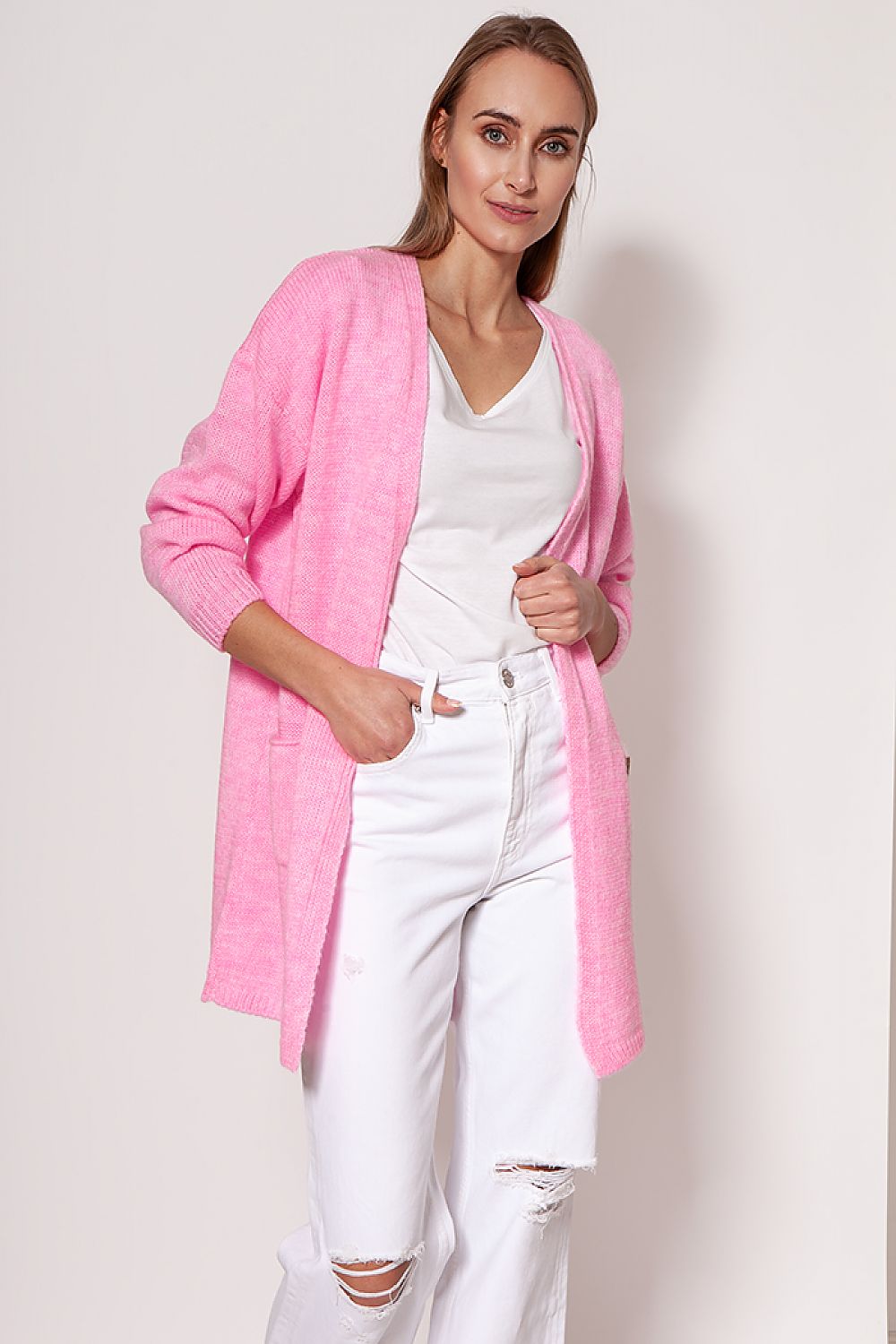 Model showcasing a luxurious pink melange knit cardigan by MKM, featuring dropped shoulders and hip pockets, paired with white distressed jeans for a chic look.