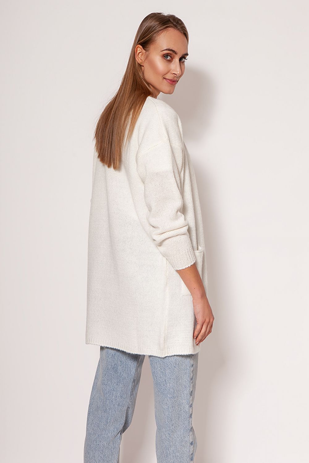 Stylish MKM white melange knit cardigan, featuring a relaxed fit with dropped shoulders and visible hip pockets, presented on a model from a side angle.