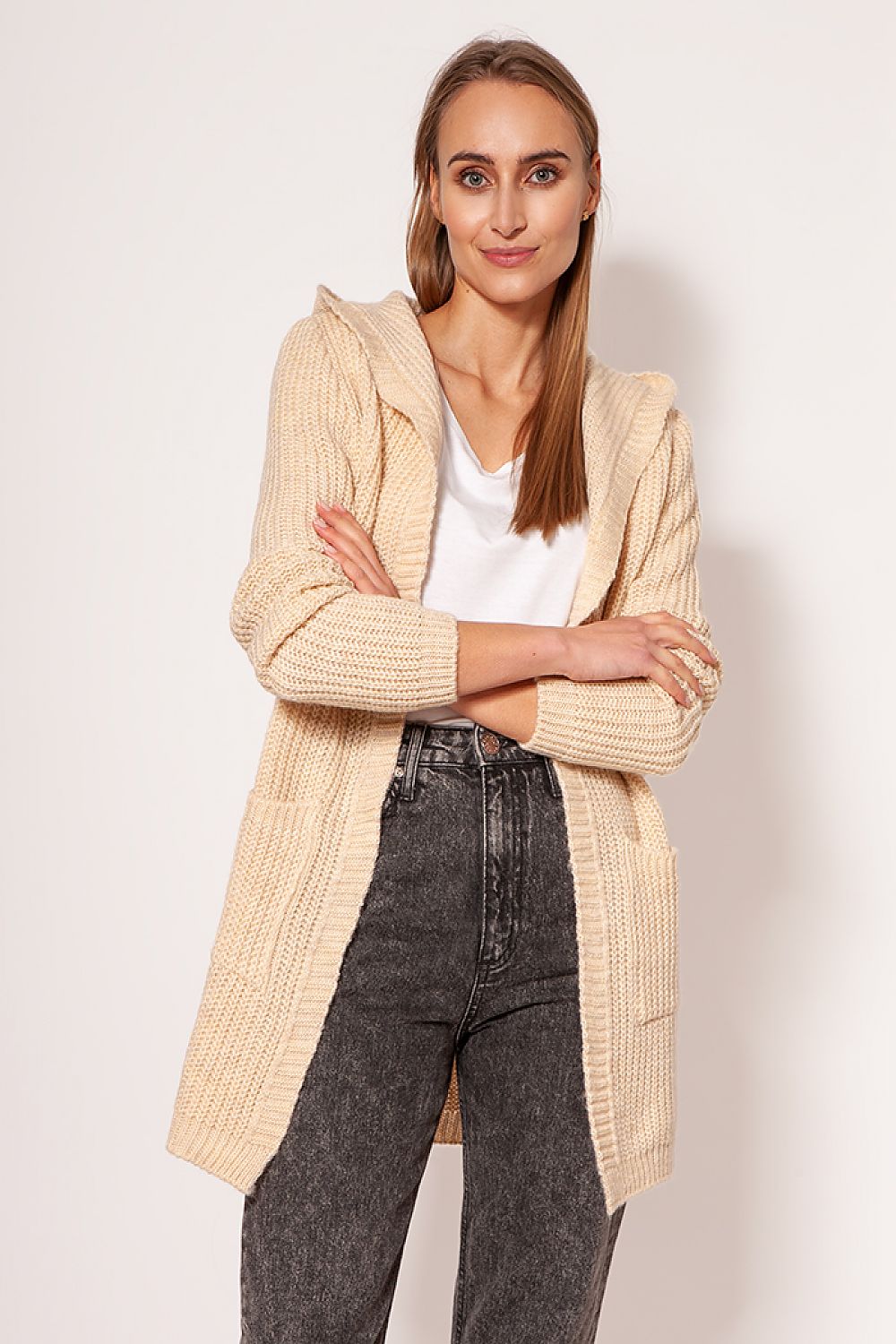 MKM luxurious soft cardigan coat with minimalist design, featuring a hood and hip pockets, modelled casually by a woman in light beige tones, perfect for chic and comfort wear.