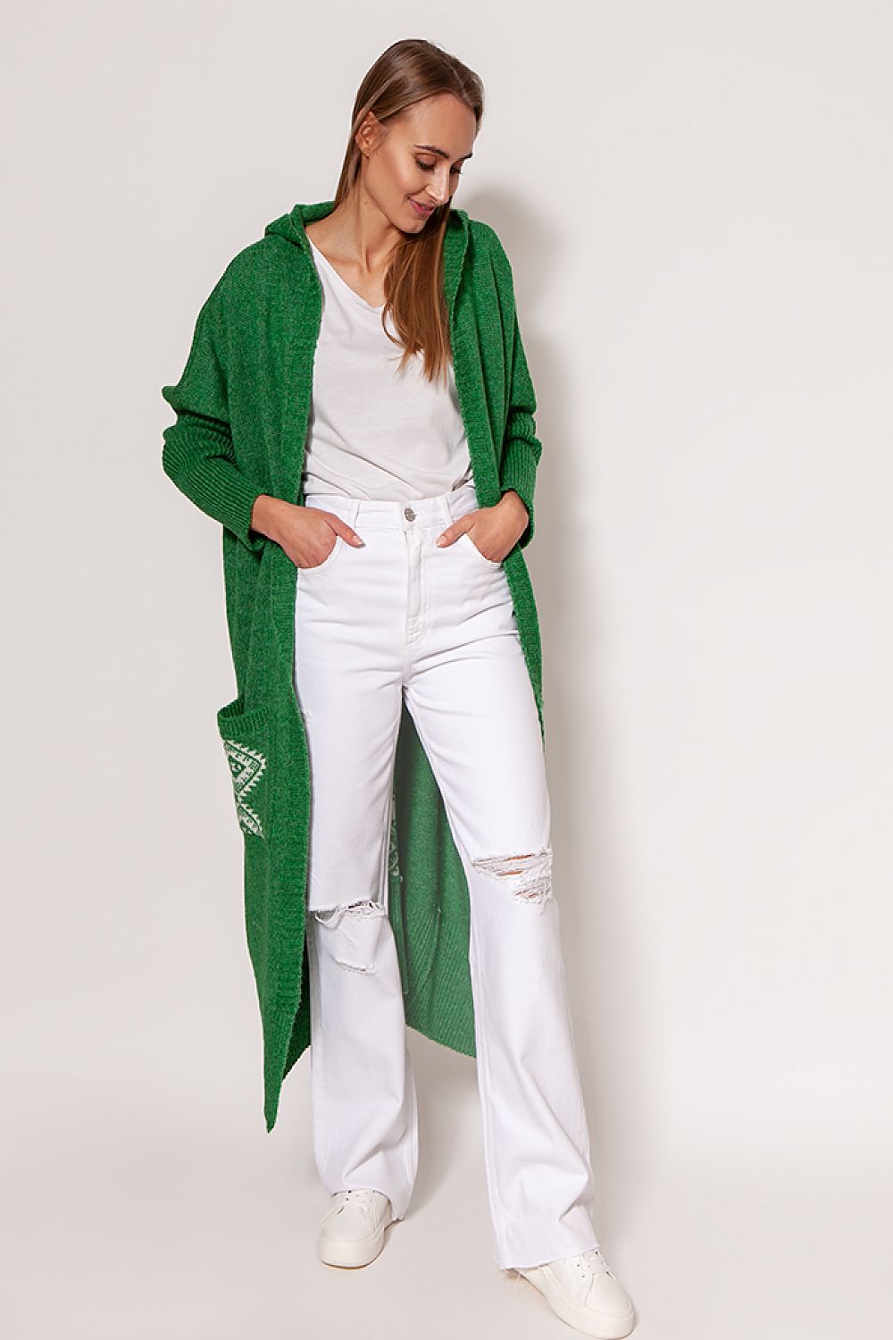 Chic MKM green extended cut cardigan with hood and pockets, beautifully paired with white jeans, showcasing a cozy yet fashionable look for various occasions.