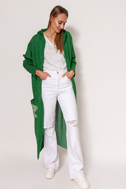 Chic MKM green extended cut cardigan with hood and pockets, beautifully paired with white jeans, showcasing a cozy yet fashionable look for various occasions.