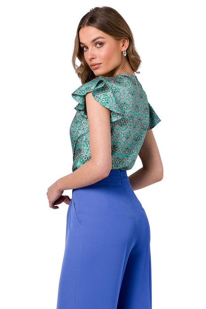 Stylove luxurious satin blouse in vibrant floral patterns, featuring a V neckline and ruffle sleeves, expertly paired with tailored blue trousers.