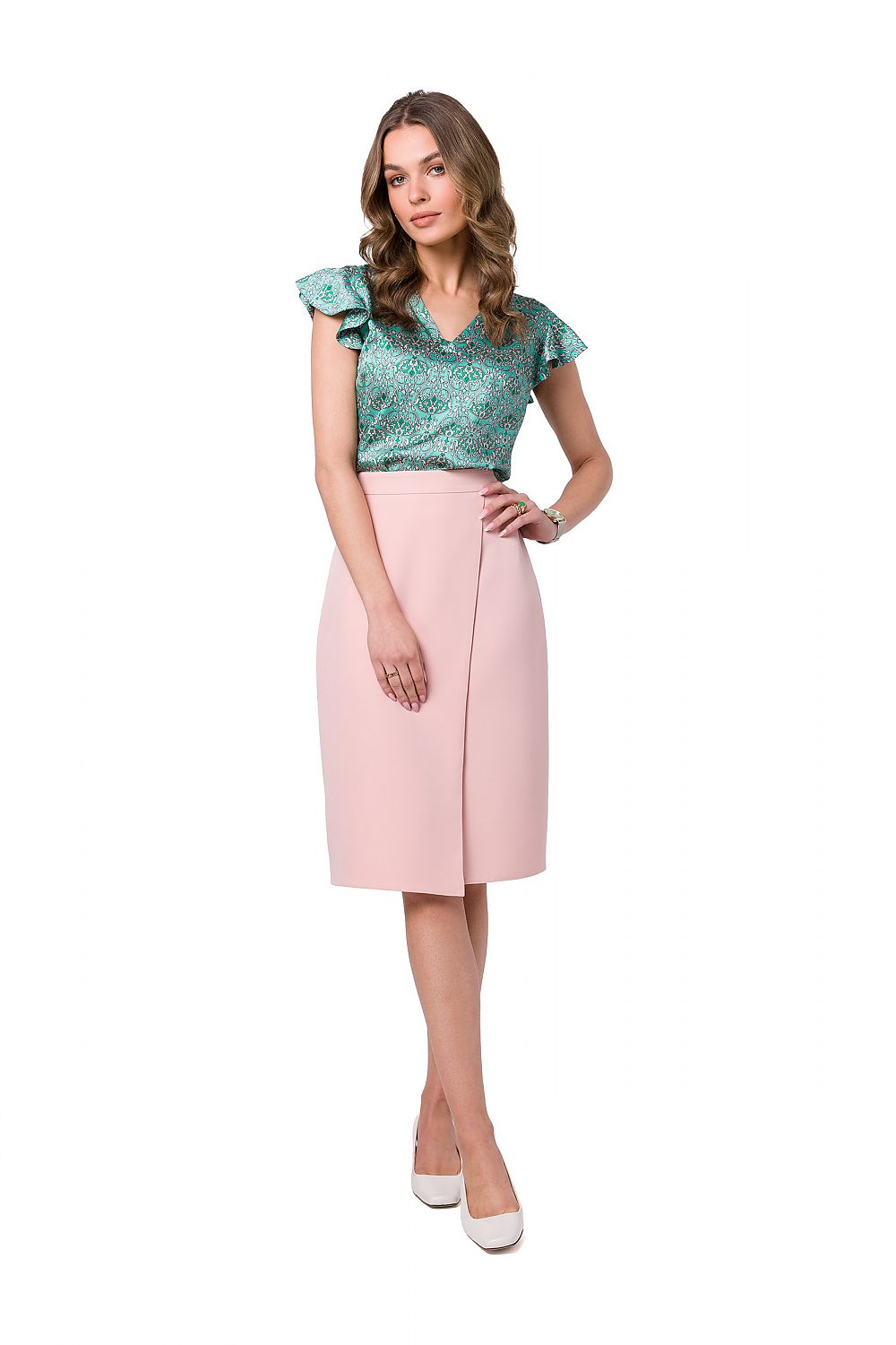 Stylove Classic A-Line Skirt in soft pink featuring an asymmetrical front design, modelled elegantly with a colourful top and chic white heels.