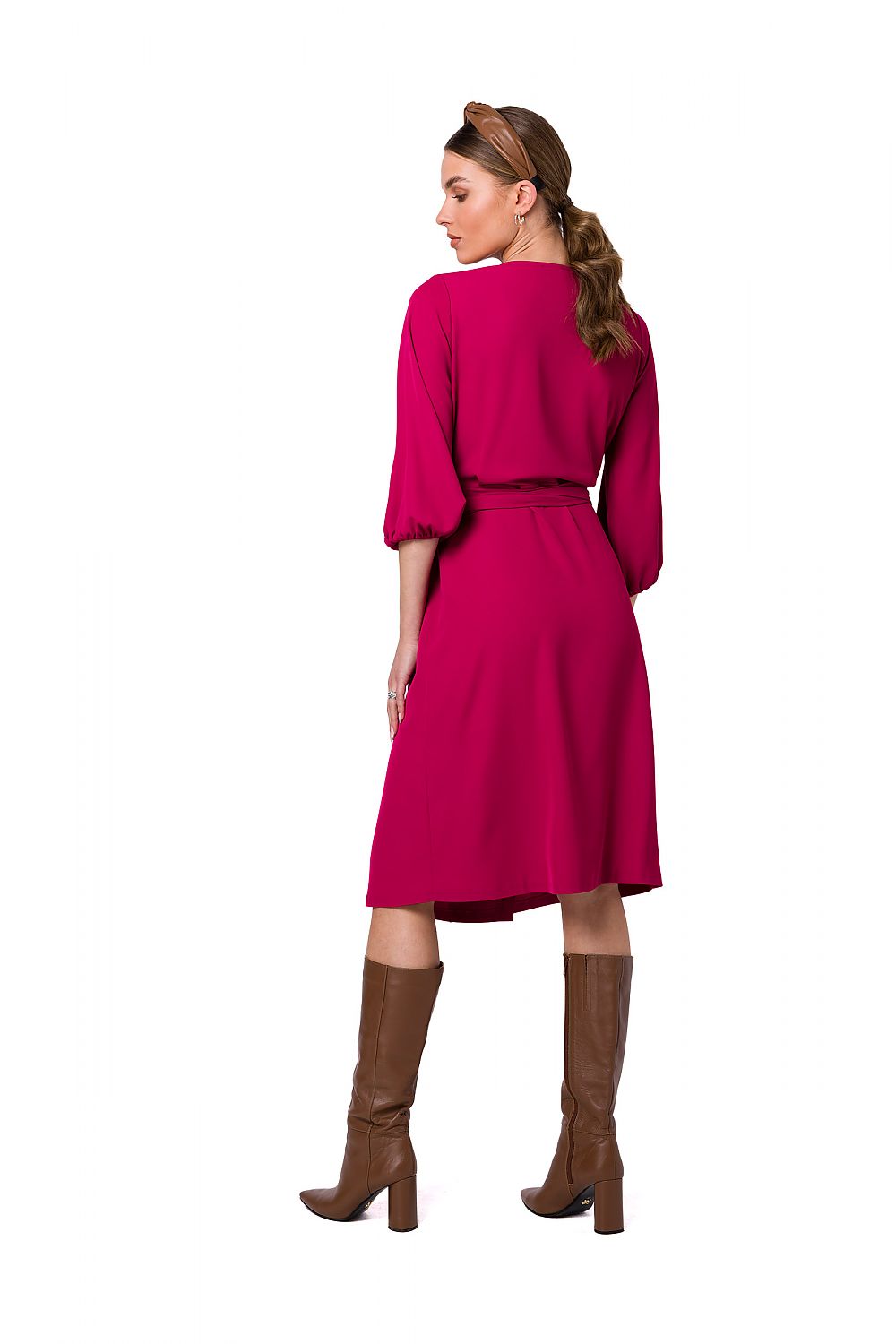 Back view of the Stylove Flared Overlap Dress in bold pink, highlighting its flowy silhouette and wide sleeves, paired with stylish knee-high brown boots for an elevated look.