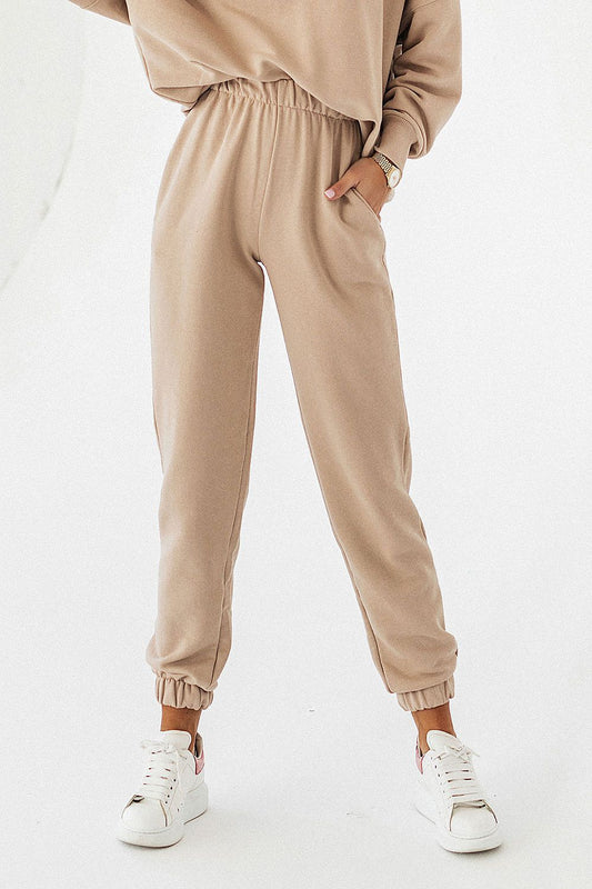 Luxurious cotton blend joggers by IVON in a chic beige hue, featuring a drawstring waist and side pockets, elegantly styled for comfort and sophistication.