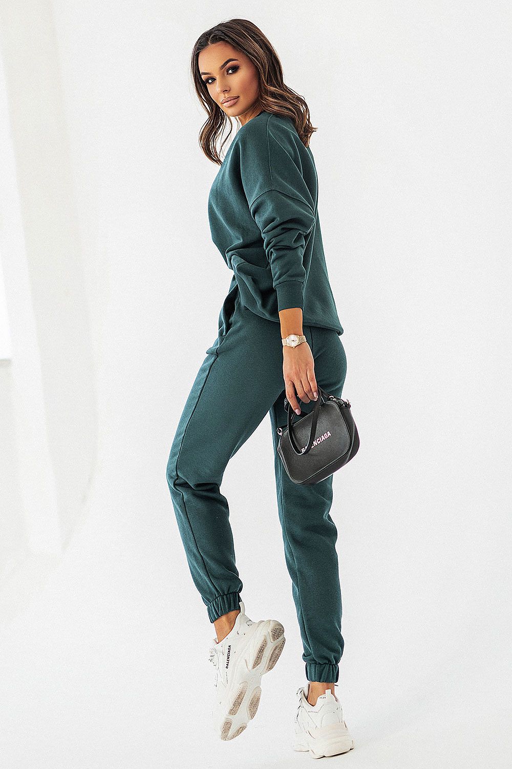 Fashion-forward IVON dark green joggers featuring a relaxed fit and chic details, complemented by a fashionable watch and handbag.