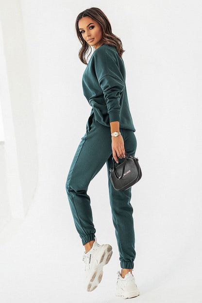 Fashion-forward IVON dark green joggers featuring a relaxed fit and chic details, complemented by a fashionable watch and handbag.