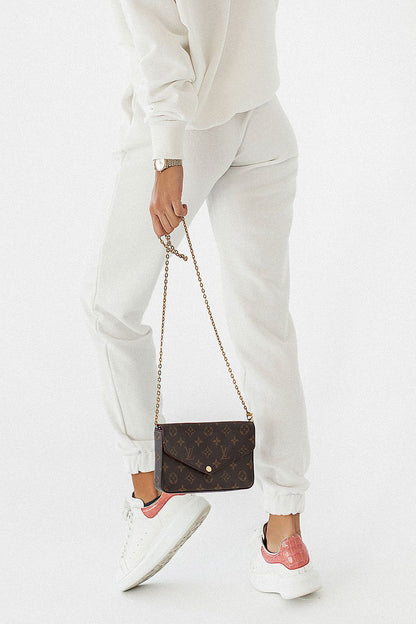 Close-up of luxury cotton blend joggers IVON, featured in white, complemented by a matching top and stylish handbag, perfect for relaxed yet elegant ensembles.