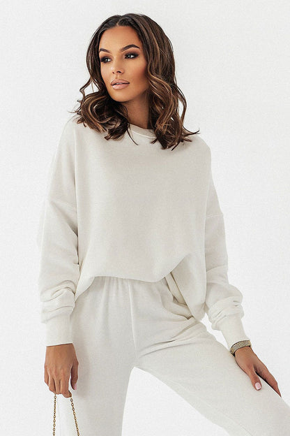 Stunning woman wearing the IVON oversized sweatshirt in a serene off-white shade, exuding sophistication and comfort in a laid-back ensemble.