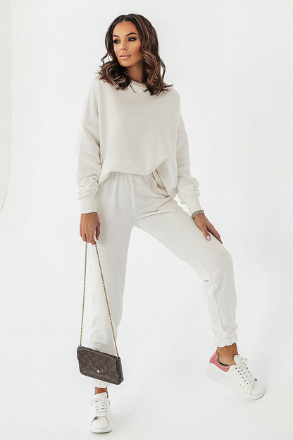 Chic presentation of a model in an off-white IVON oversized sweatshirt and joggers, accessorised with a designer bag, highlighting the perfect blend of style and leisure.