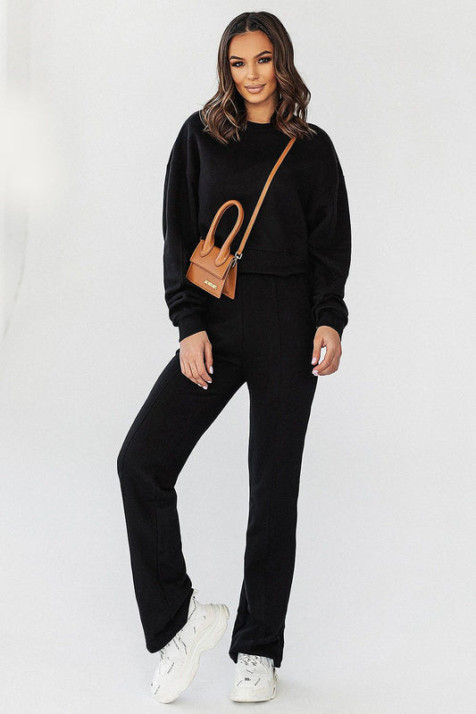 Stylish model in IVON oversized black sweatshirt paired with matching pants, exuding sophisticated comfort.