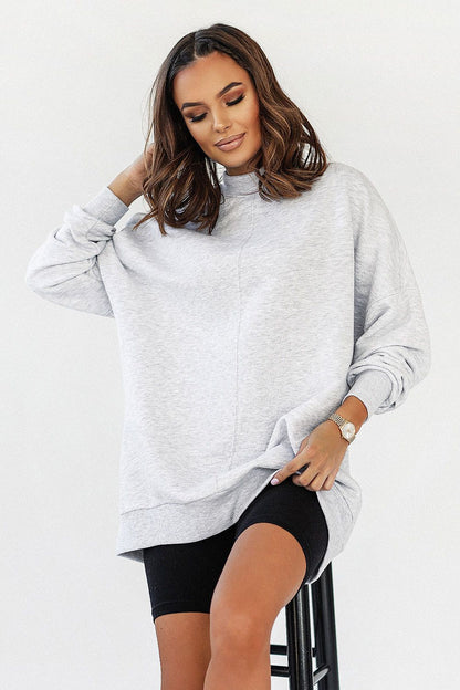Luxurious IVON extended cut sweatshirt in grey, crafted from soft cotton, features decorative stitching, a low collar, and dropped shoulders, styled casually with bike shorts.