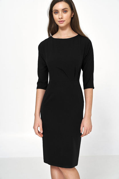 Elegant black dress featuring asymmetrical draping and 3/4 sleeves, styled by Nife. Perfect for sophisticated office wear with a flattering boat neckline.