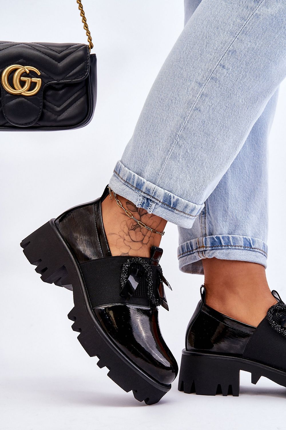 Chic black slip-on heeled half shoes from Step in Style featured against a backdrop of casual denim, highlighting its eco-friendly leather design and decorative elements, perfect for modern elegance.