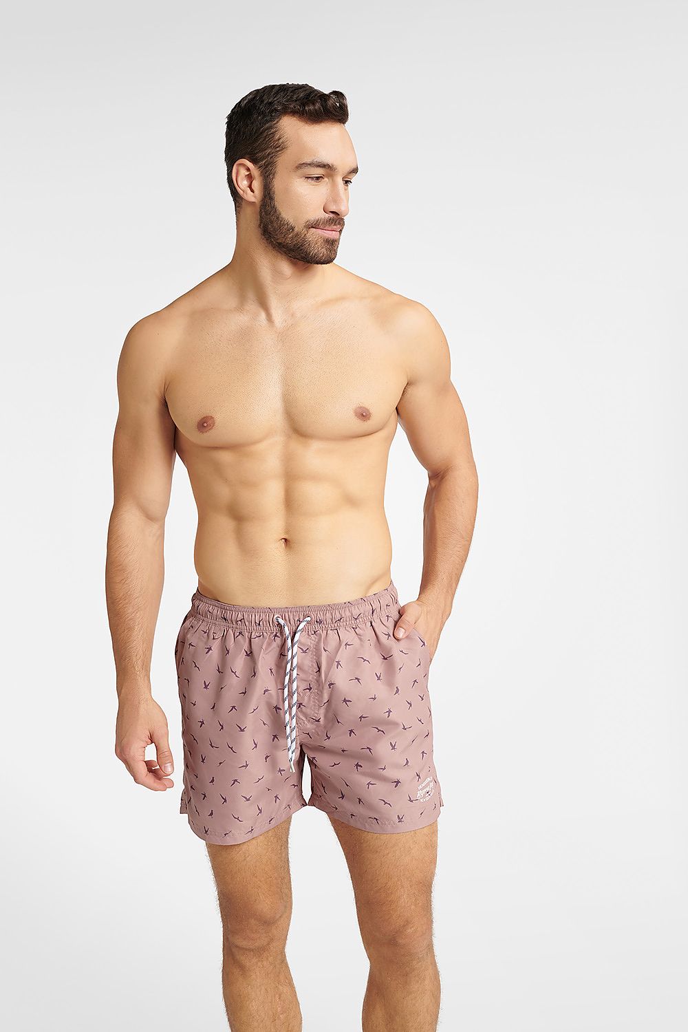 Men's GABLE Bright Pink Swim Trunks by Henderson, featuring adjustable drawstring, functional pockets, and a stylish design with bird shadow prints, model showcasing front view.