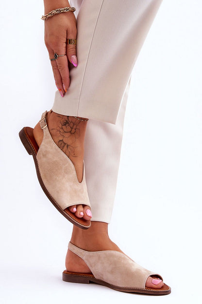 Elegant luxury leather sandals from Step in Style, featuring a chic adjustable buckle and a comfortable flat heel, showcased with stylish trousers and a beautifully tattooed ankle.