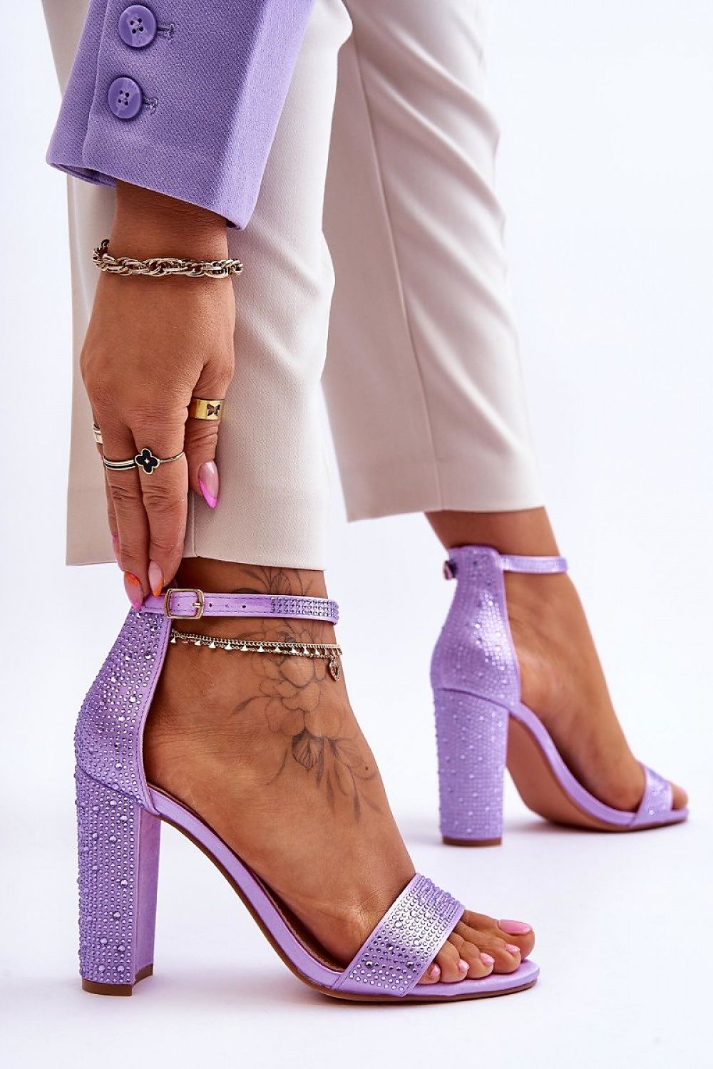 Stylish purple sandals with a sleek heel and shimmering accents, elegantly worn by a model, crafted by Step in Style.