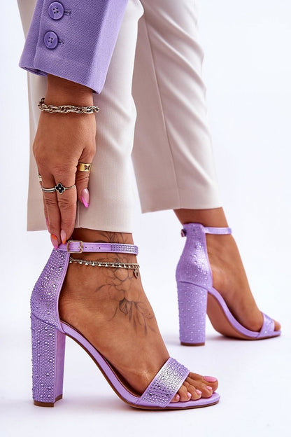 Stylish purple sandals with a sleek heel and shimmering accents, elegantly worn by a model, crafted by Step in Style.