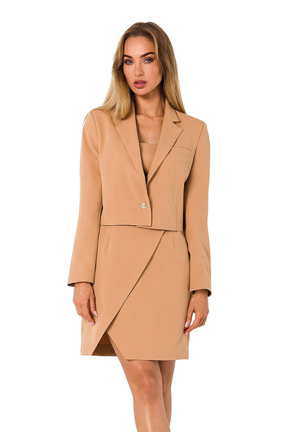 Classy beige Moe jacket with a cropped silhouette, paired elegantly with a sophisticated dress, embodying luxury and fashion-forward style.