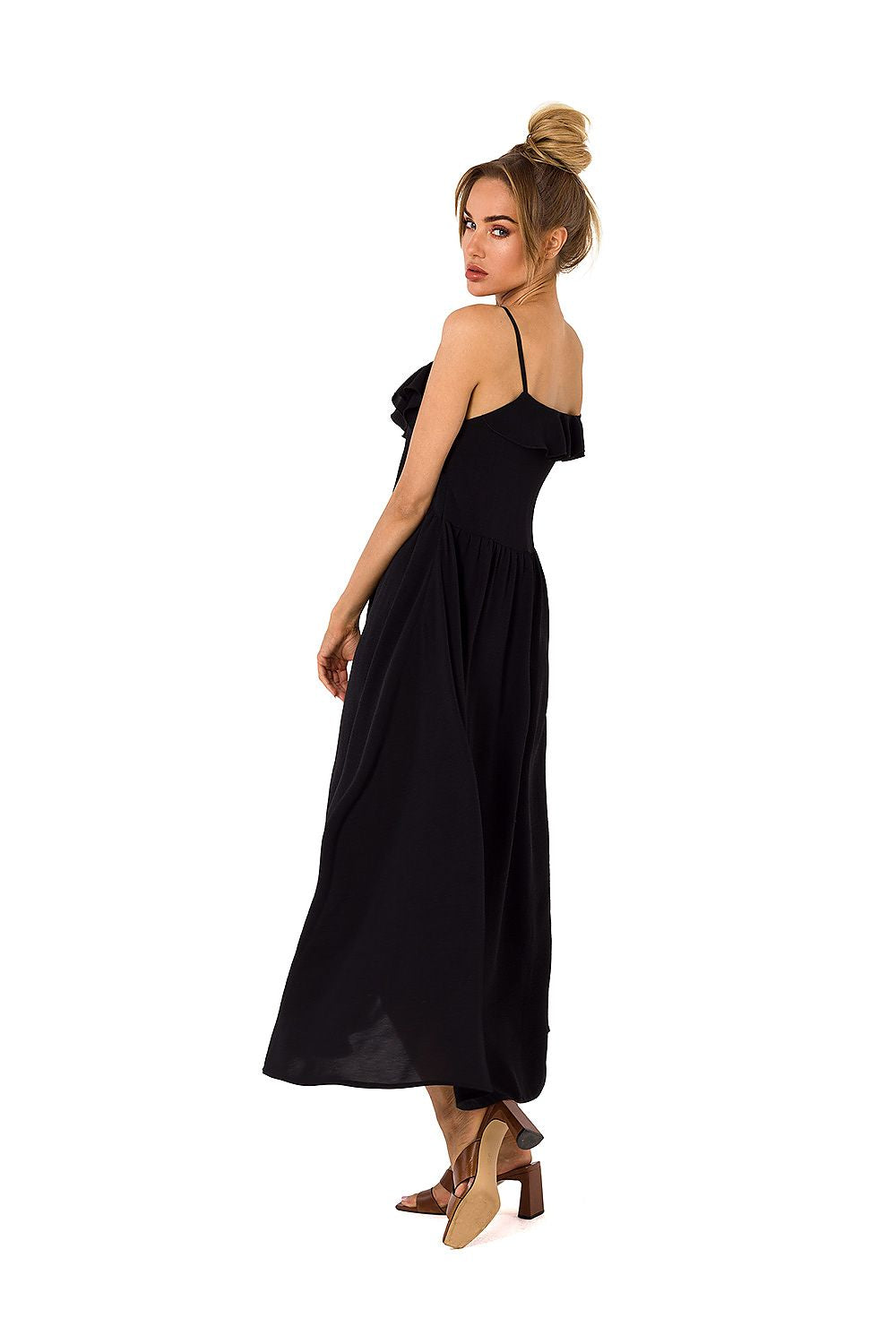 Model demonstrating the back of Moe's black loose-fitting midi dress with ruffles, combining elegance with comfort.