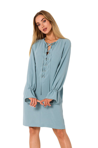 Front view of a stylish woman wearing a light blue long sleeve dress with a lace-up neckline by Moe, capturing an exquisite blend of sophistication and comfort.