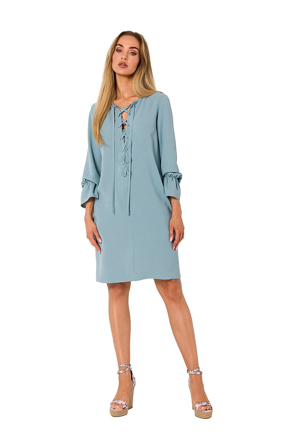 Chic portrayal of a woman in a blue long sleeve ruffle dress by Moe, featuring a flattering fit and elegant design, ideal for fashionable gatherings.