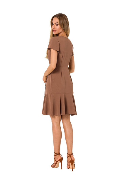 Back view of the Moe Airy Overlap Day Dress in brown, displaying the stylish ruffle finish and side tie design, worn by a model with flowing hair.