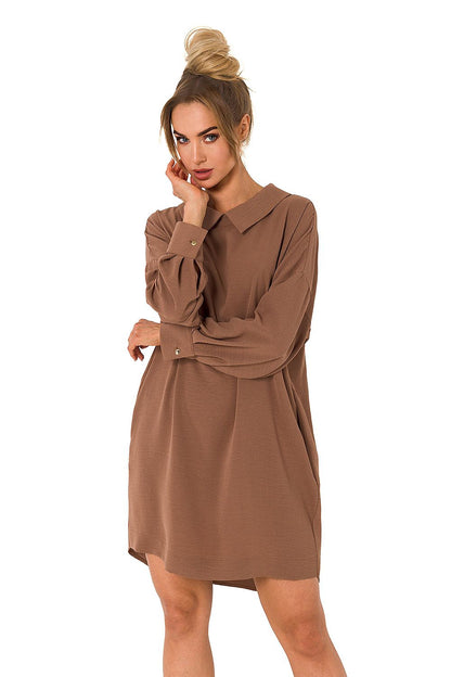 Elegant Luxury Moe daydress featuring a sophisticated collar and chain detail, designed with long sleeves and a relaxed fit, perfect for versatile styling. The model showcases the dress in a rich brown shade, suitable for sizes S to XXL.