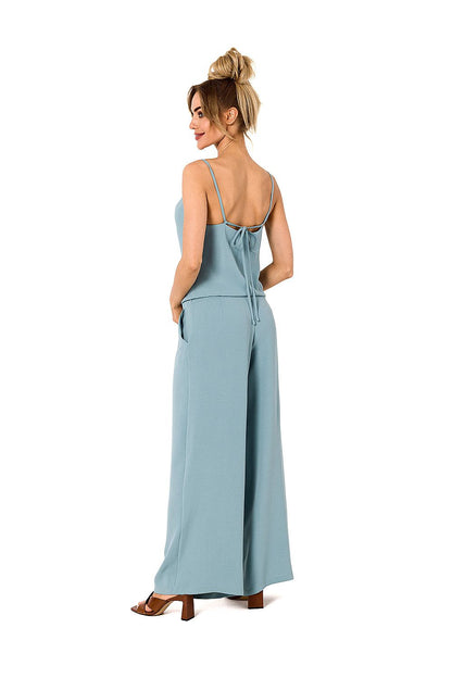 Sophisticated light blue pantsuit with a flattering draped neckline and adjustable tie-back details, presented by Moe for a stylish ensemble.