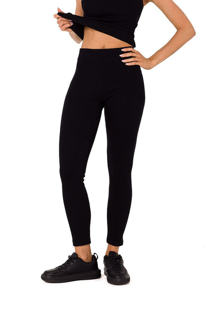 Chic black Moe ribbed knit leggings paired with a matching tank top, exuding sophistication and elegance in a sleek design.