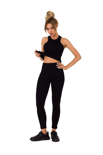Elegant model in black Moe ribbed leggings and tank, presenting a stylish athleisure look ideal for both casual and upscale settings.