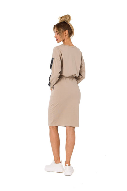 Elegant back view of a woman wearing Moe women's knit sweatshirt skirt in beige, featuring an elastic waistband and pockets.
